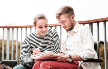 Man and woman writing on notepad