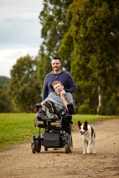 Support worker with man and dog in park