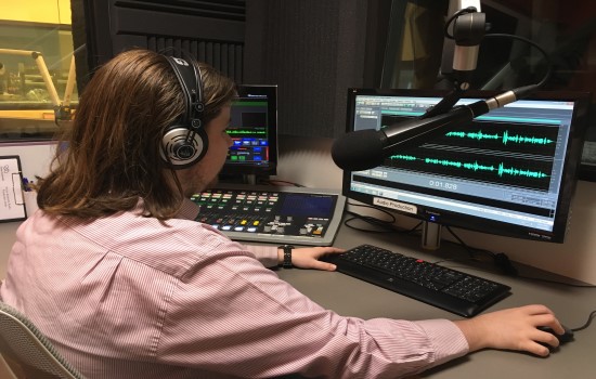 Vision Australia radio volunteer  on computer with microphone