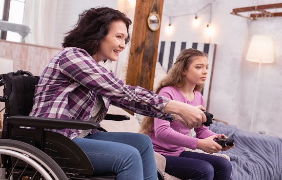 Woman in wheelchair and daughter playing video game