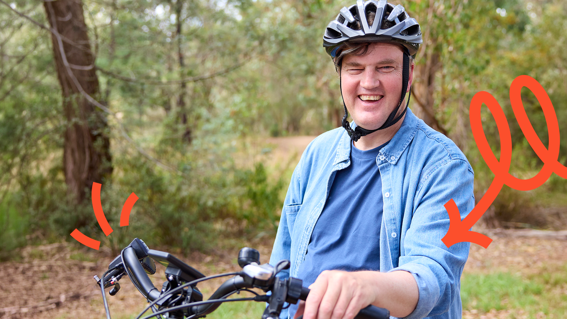 Man in blue shirt smiling riding a bike