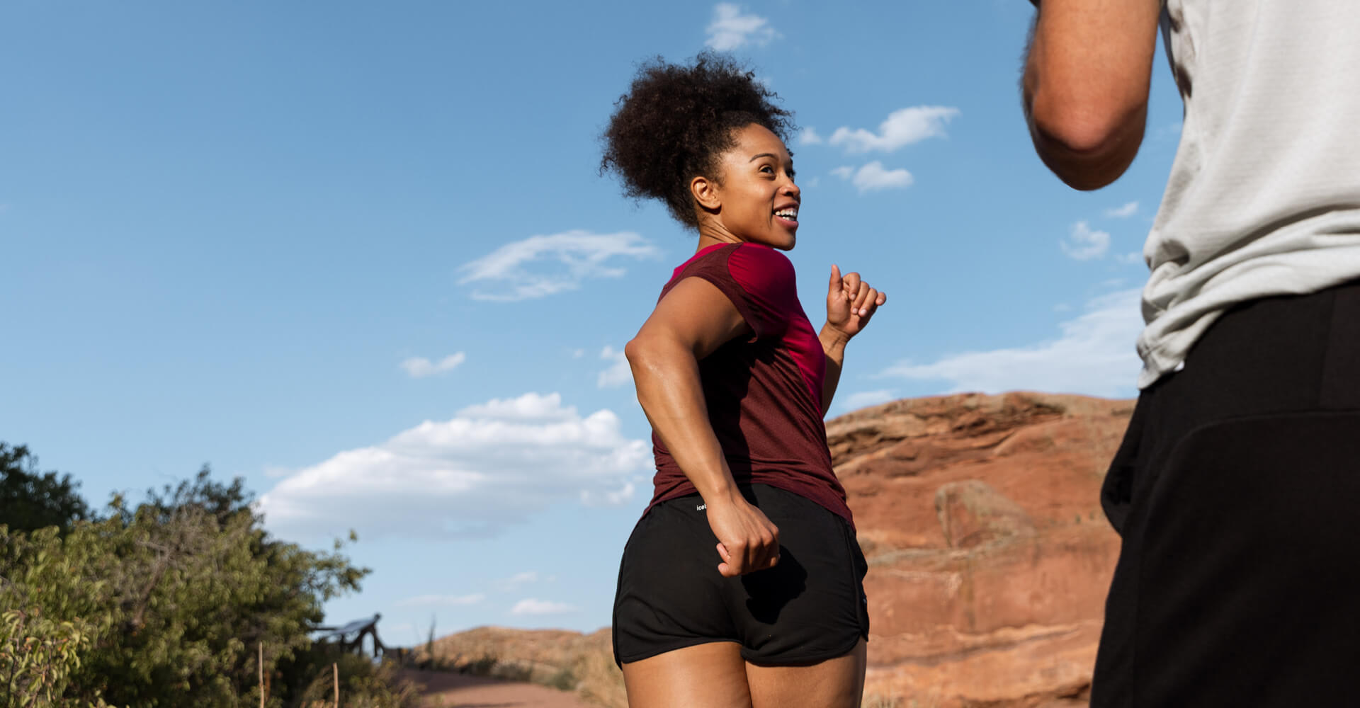 Man running and wearing ZoneKnit™ Merino Short Sleeve Tee in Ether and women wearing ZoneKnit™ Merino Short Sleeve Tee in Black.