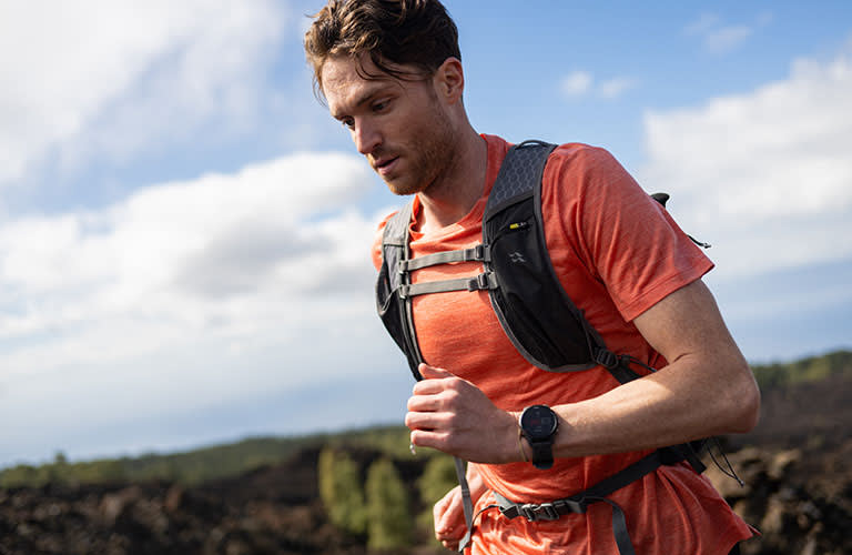 Man running wearing an orange icebreaker sphere merino t-shirt