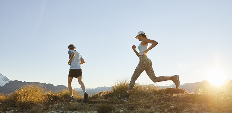 Man and woman trail running at sunrise