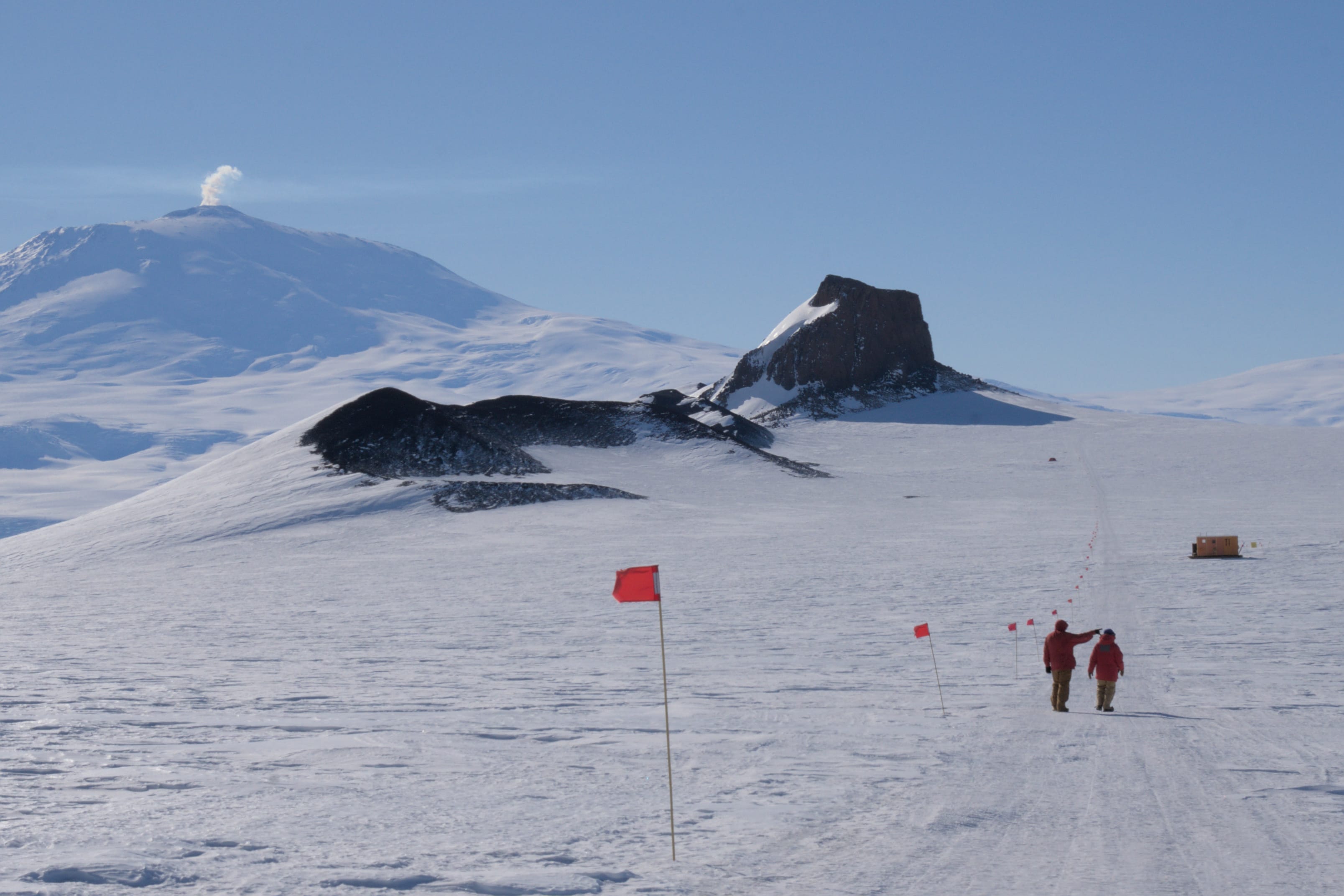 Two winterovers hiking toward Castle Rock.