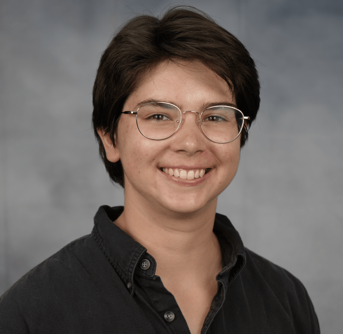 A headshot of a woman with short brown hair and glasses.