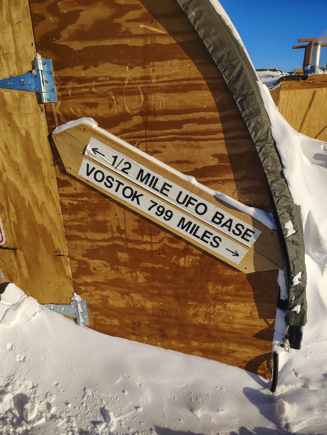 Silly sign pointing to UFO base and Vostok station in opposite directions