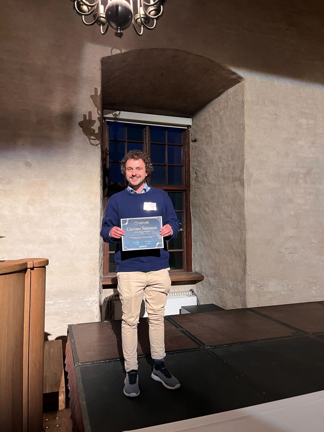 A man standing on stage holding a certificate