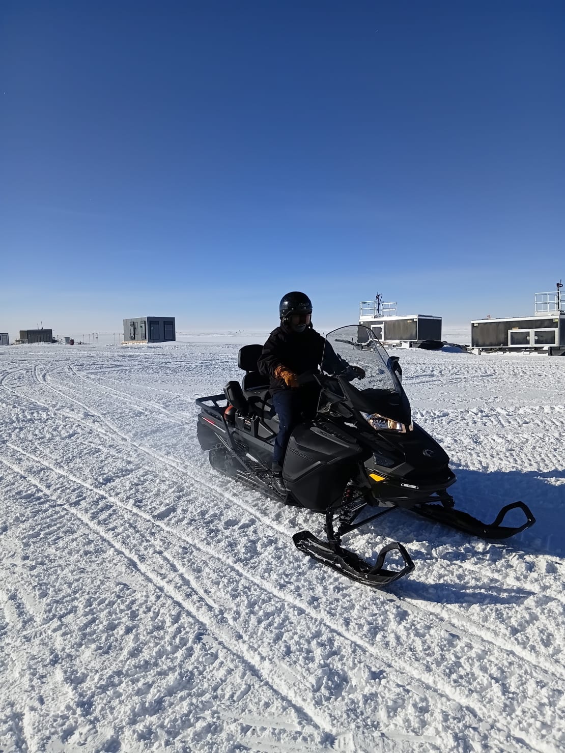 Three-quarter view close-up of person on a snowmobile.