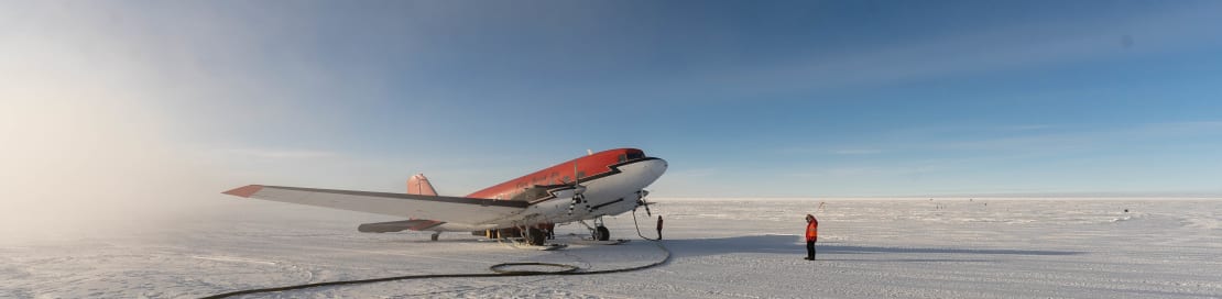 Wide-angle view of South Pole ski way with Basler plane parked during refueling.