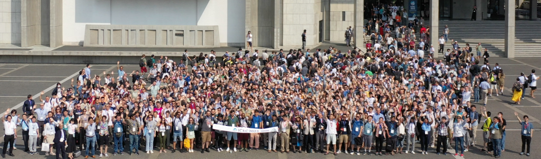 A drone shot of a large group of people standing outside of a building