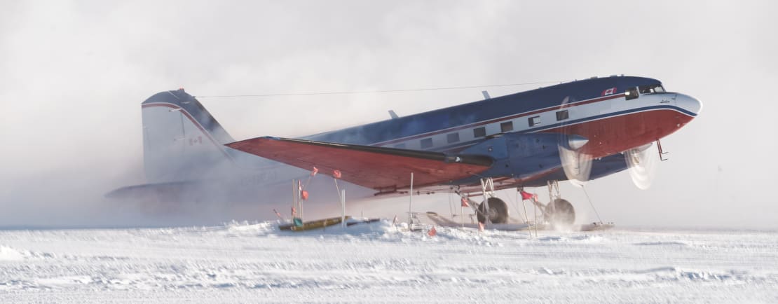 Side view of a Basler plane as it is landing on the ice at the South Pole.