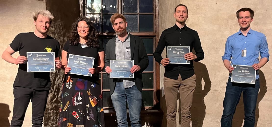 A group of people standing on stage while holding certificates