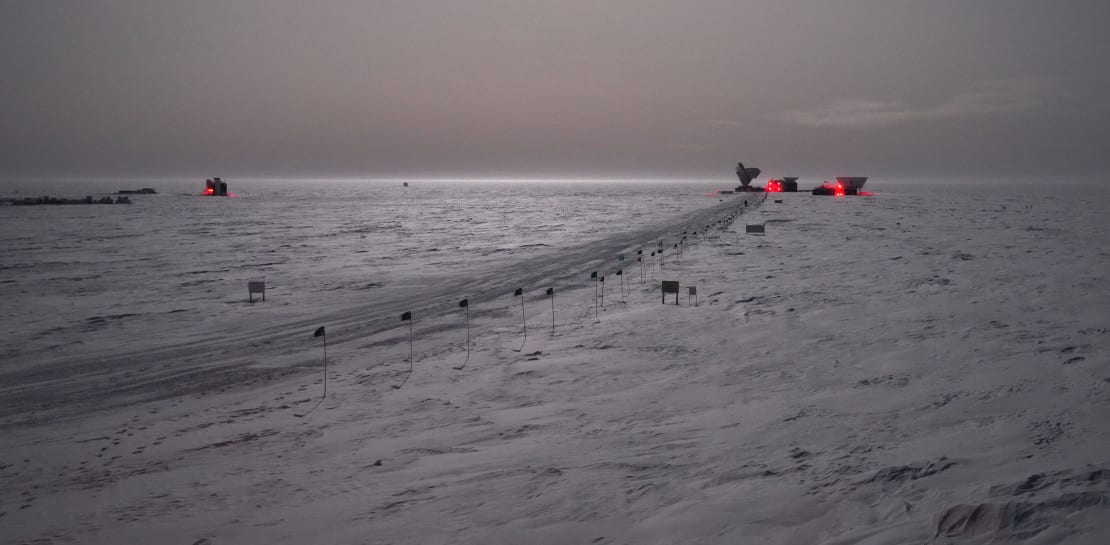 Winter view of dark sector buildings in the distance under skies brightened by moonlight.