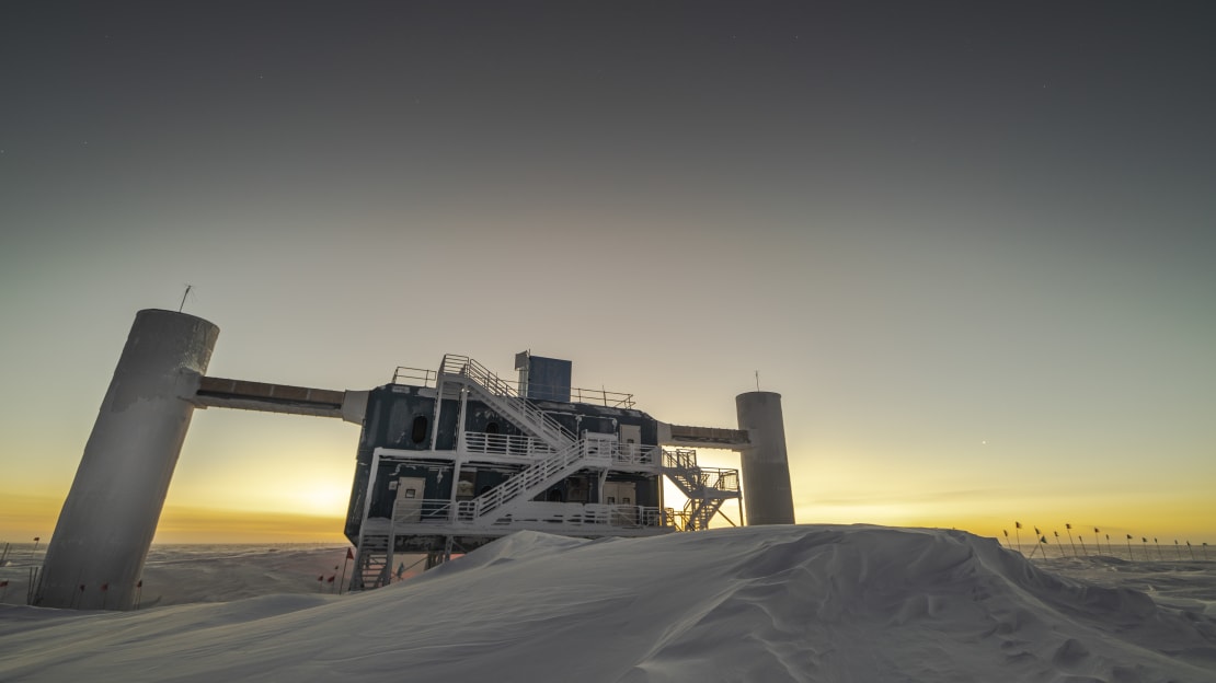 The IceCube Lab at dawn with yellow sky along horizon.