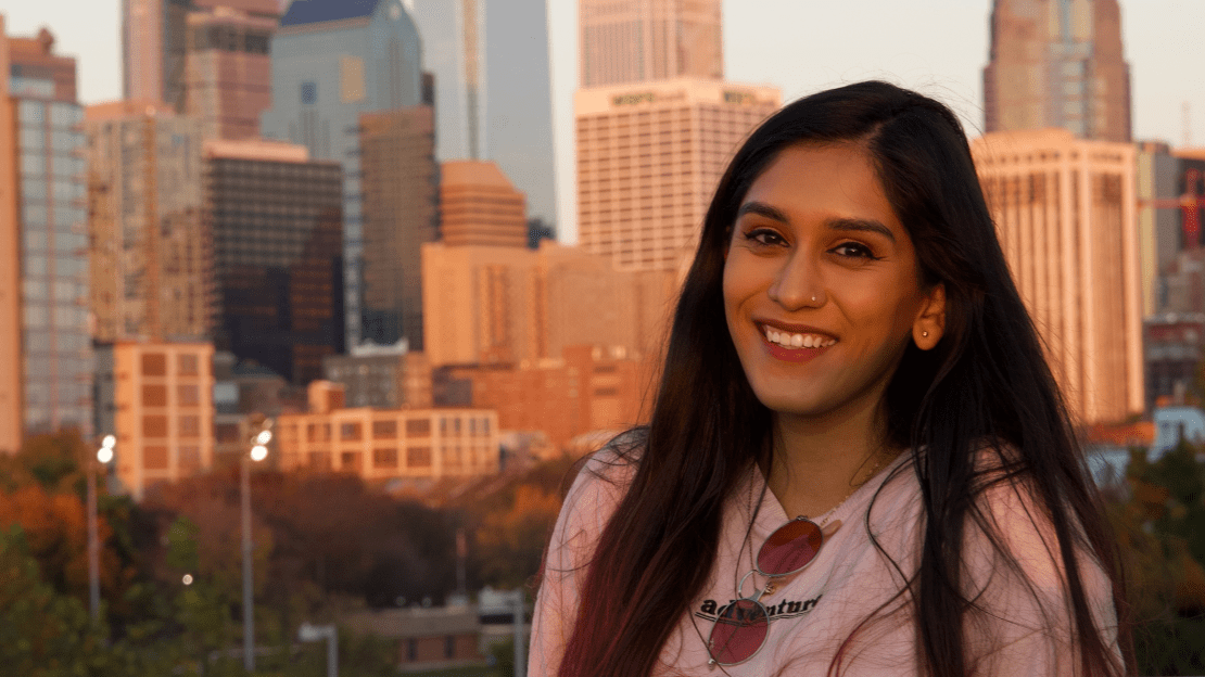 A person smiling in front of a skyline