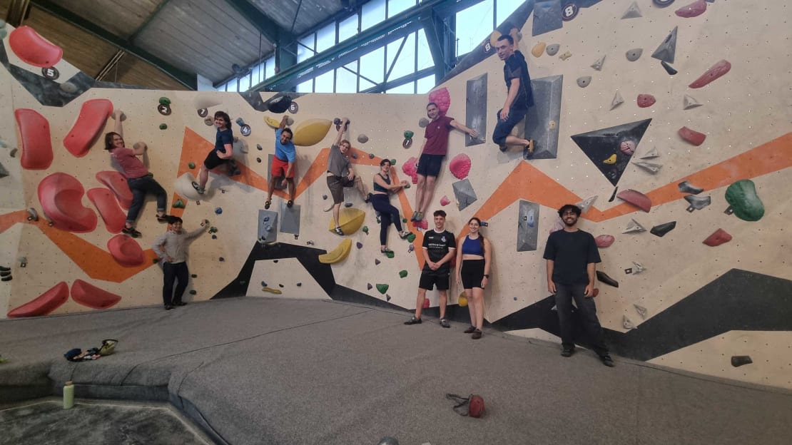 A bunch of people on a wall at a bouldering gym.