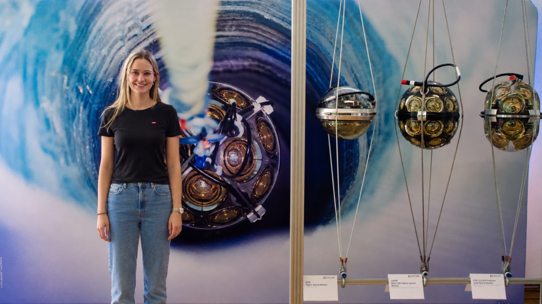 A person standing in front of a mural with a bunch of light sensors on display to the side.