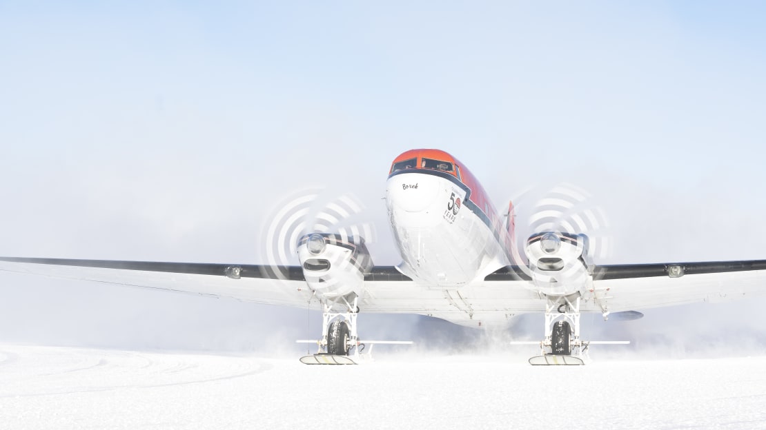 Front view of small plane arriving at the Pole, propellors still twirling.