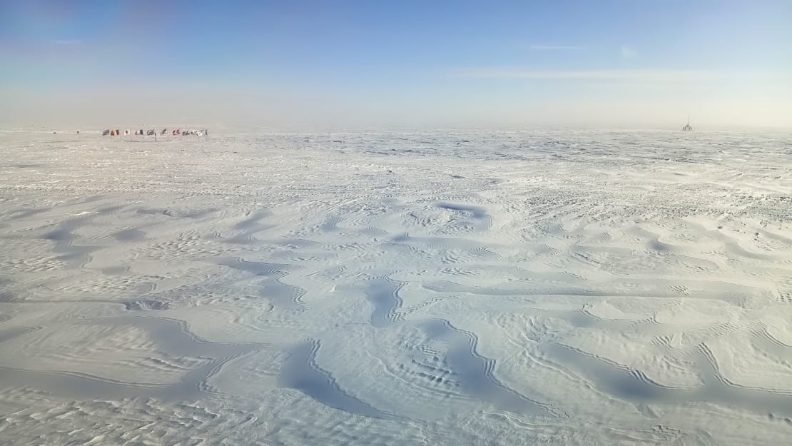 Windswept ice displaying lots of wavy lines and patterns of divets in the surface.