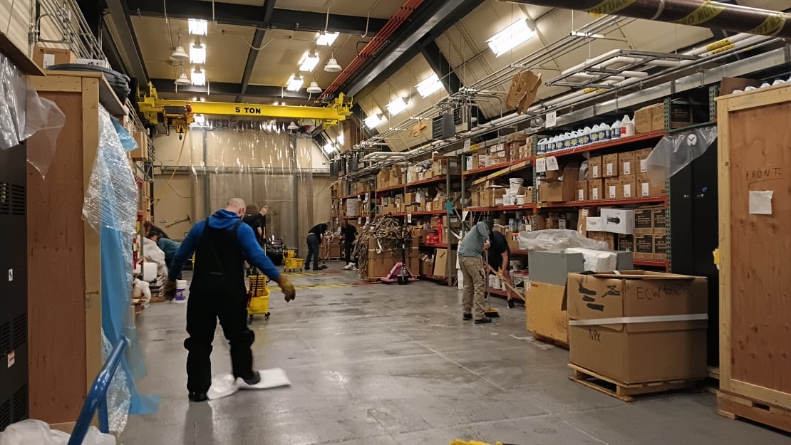 Several people working in warehouse/garage.