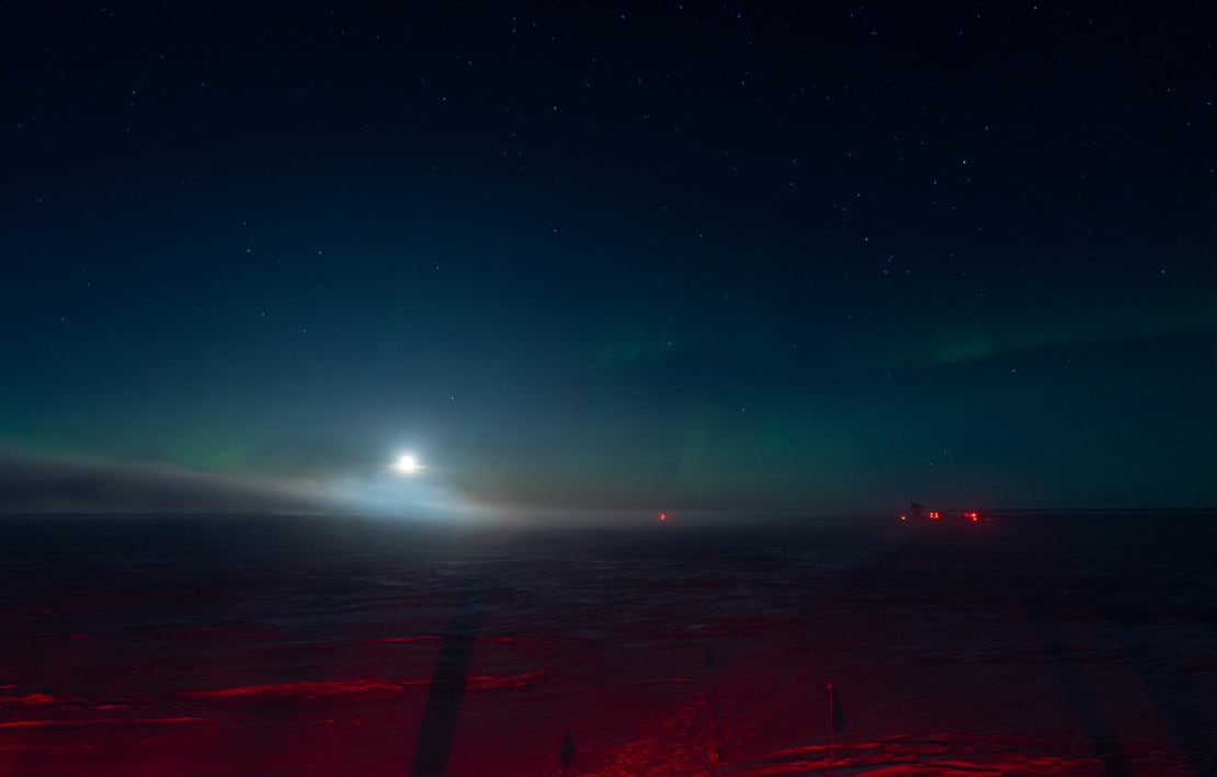 A low but very bright moon in a dark, somewhat bluish South Pole sky.