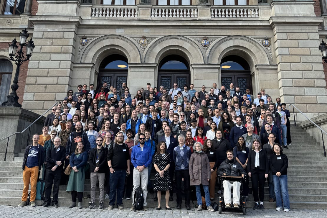 A group photo of people standing on steps in front of a building.
