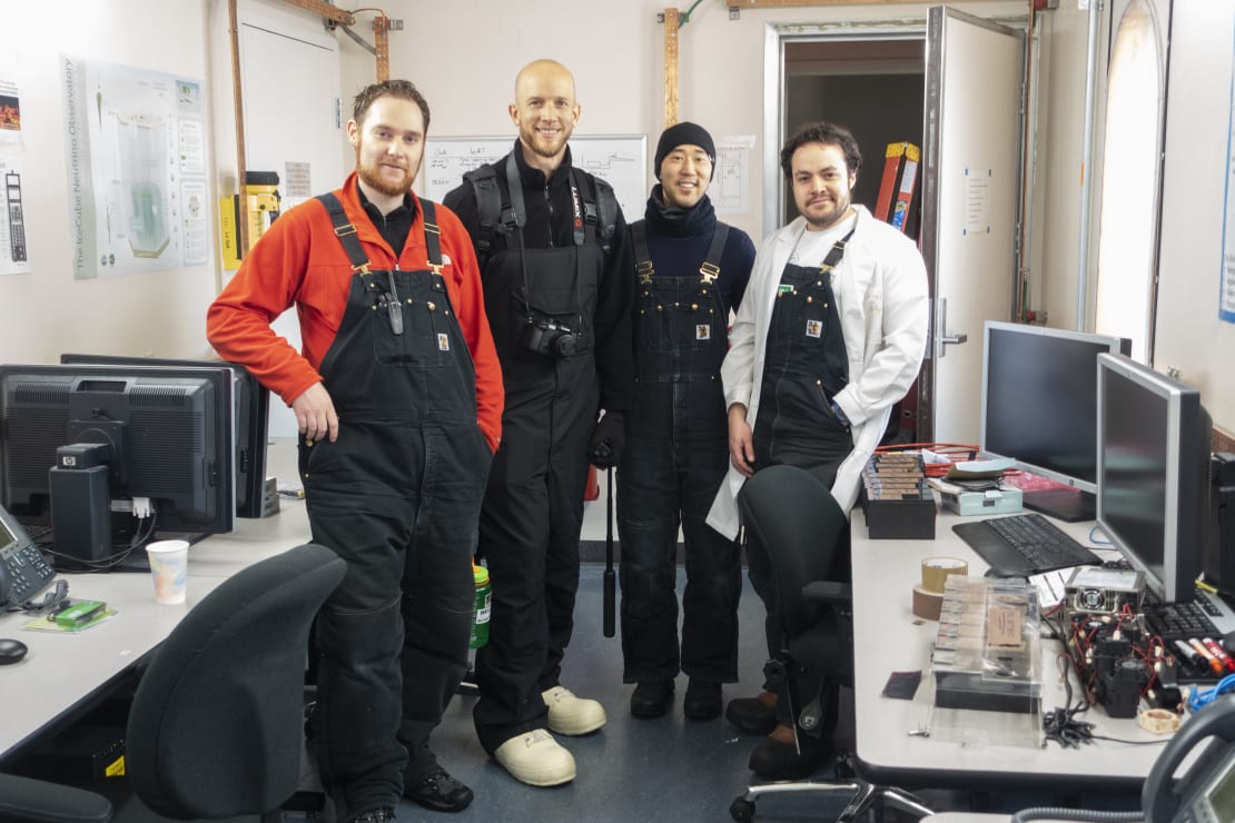 Group of four standing and facing camera in computer lab.