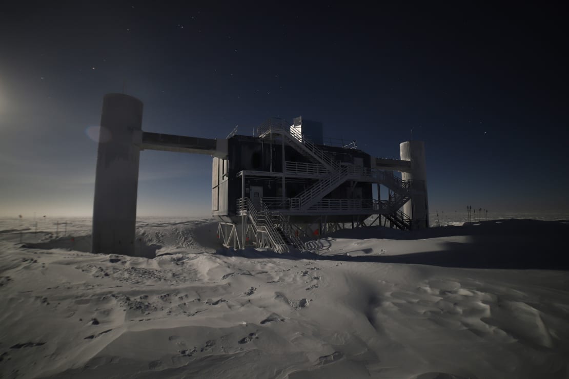 The IceCube Lab lit from behind by moonlight.