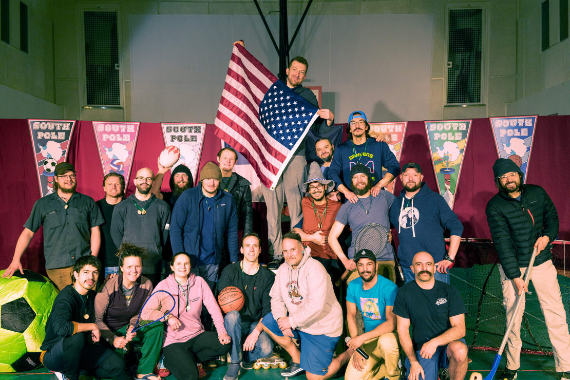 Group photo of South Pole Polympics participants, one holding up US flag.