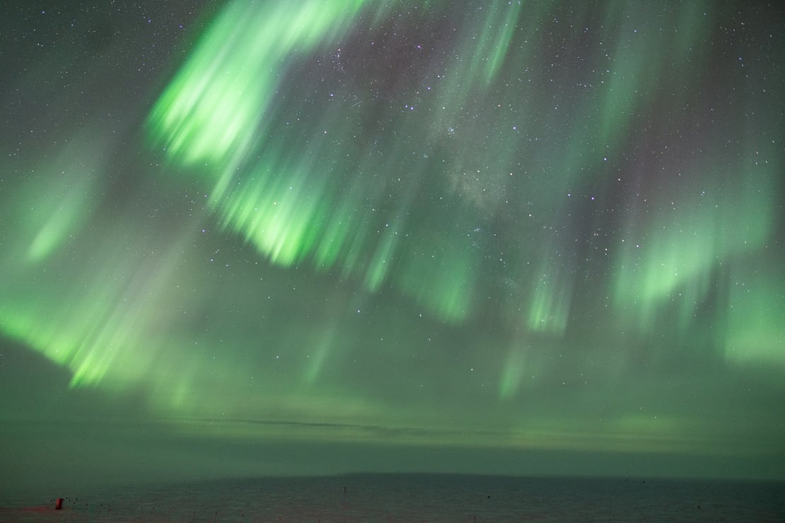 Streaky bands of green auroras filling the sky.