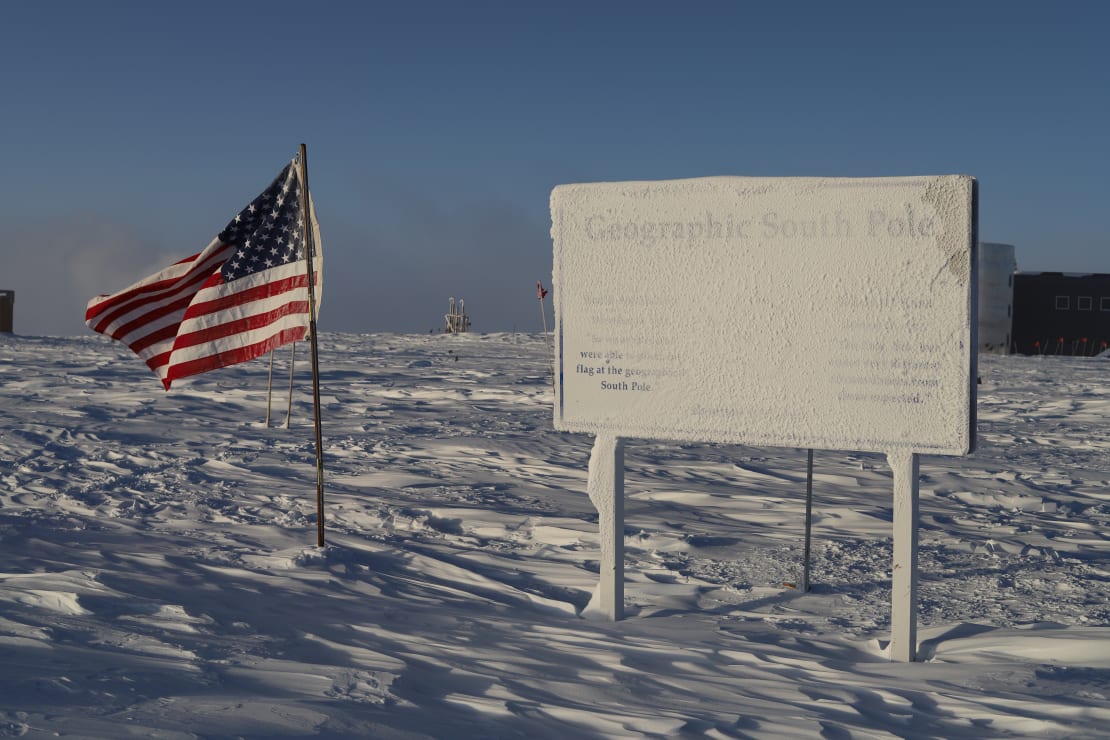 Snow-covered sign at geographical South Pole.