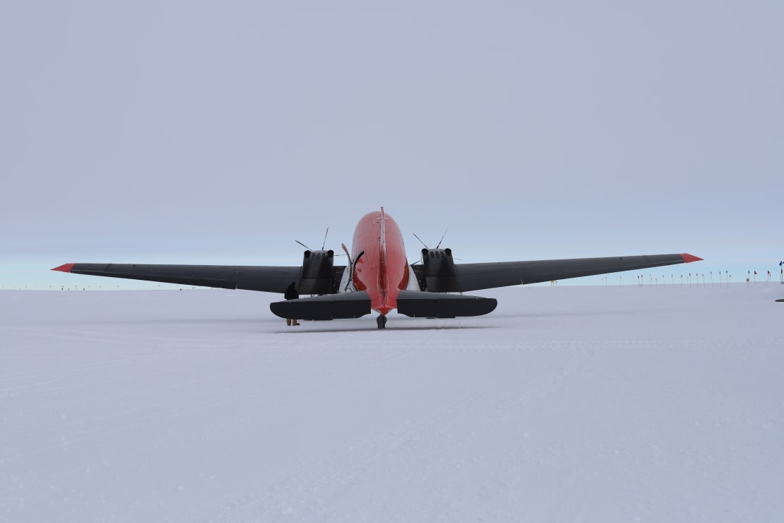 Small Basler aircraft parked on the South Pole ice, seen from behind.