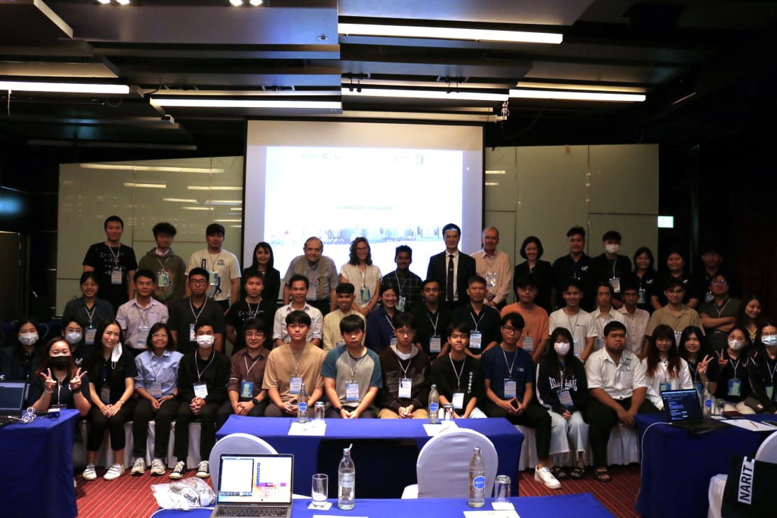 A group photo of a bunch of people at the front of a room