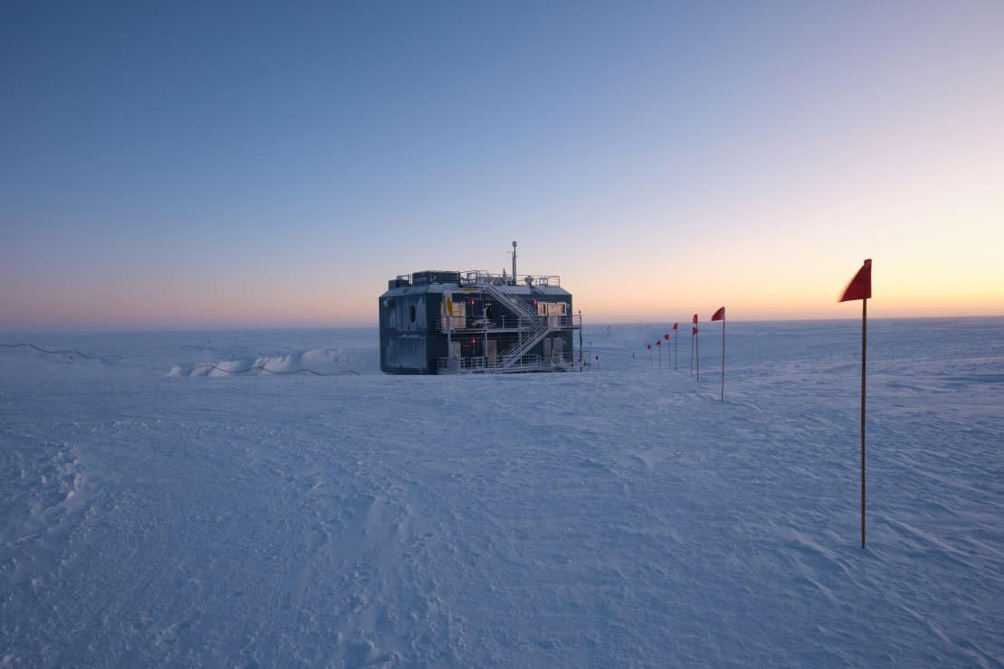 The ARO building at the South Pole at sunset, with lingering yellow light on horizon off to the right.