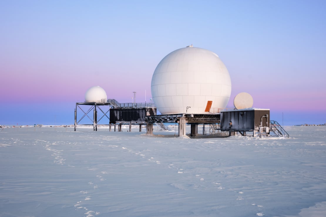 Beautiful layers of colored sky at sunset behind the satellite domes at the South Pole.