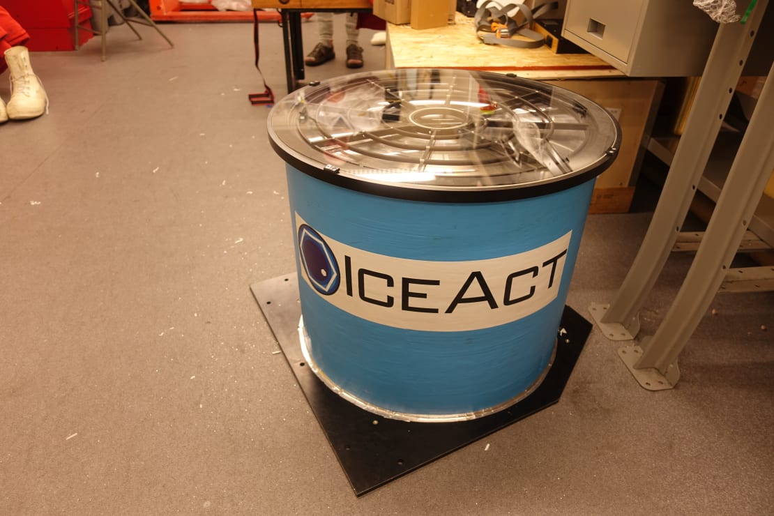 Close up of new instrumentation, a short cylindrical telescope apparatus, labeled on front with “IceAct.”
