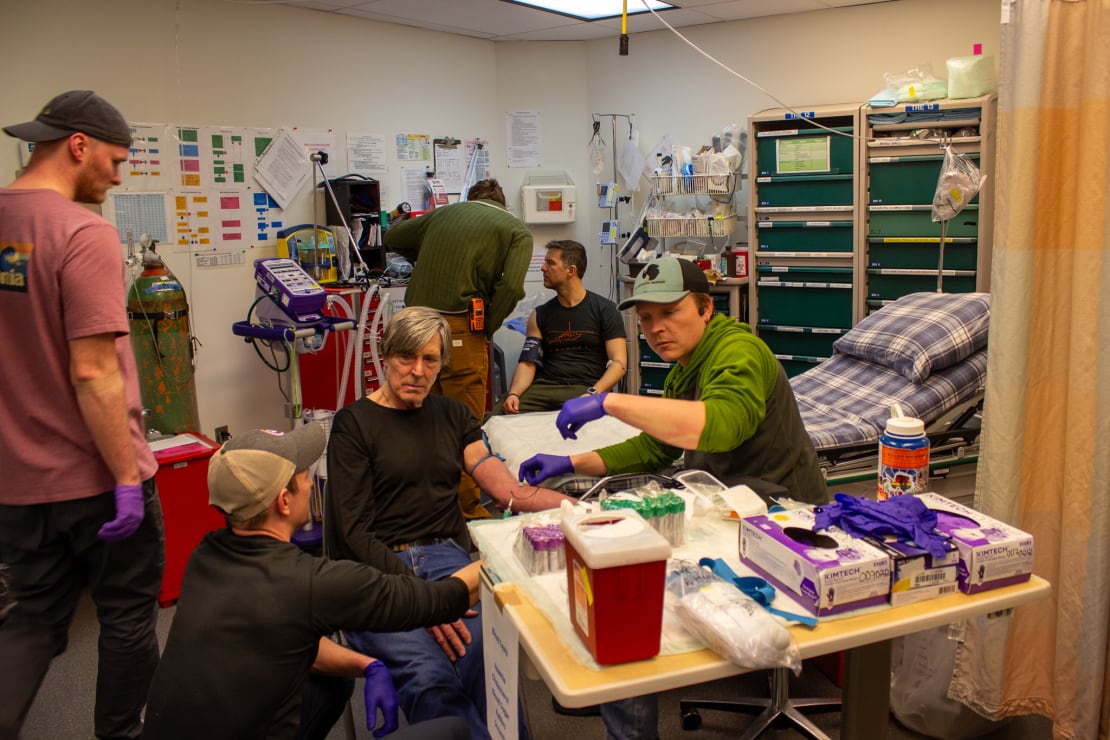 A number of people practicing medical procedures during a wellness session in the South Pole medic’s room.