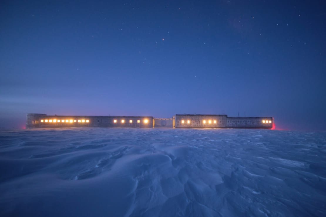 South Pole station at twiglight, with all the windows uncovered and illuminated.