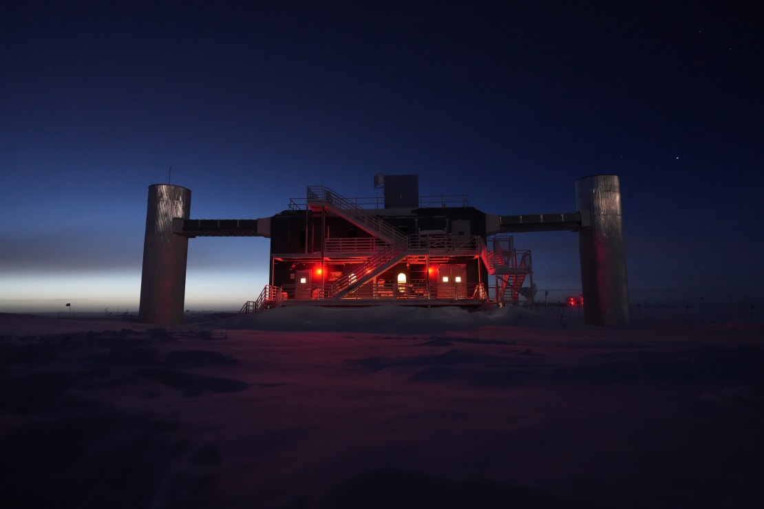 A band of bright moonlight peeking from behind the IceCube Lab in shadow.