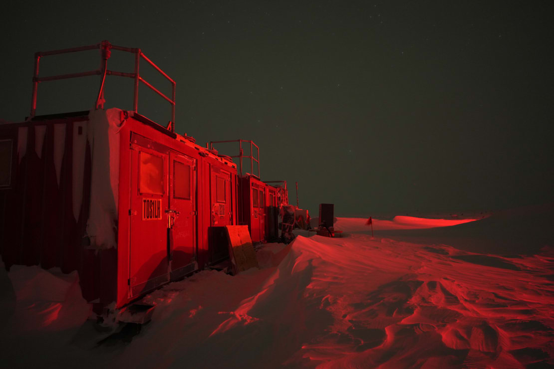 Frosted storage container illuminated in red, dark skies in background.