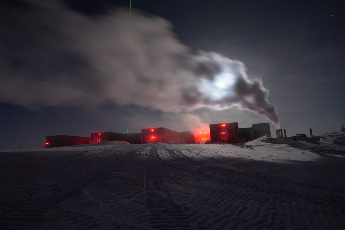The South Pole station with its red lights and the power plant exhaust blocking the moon.