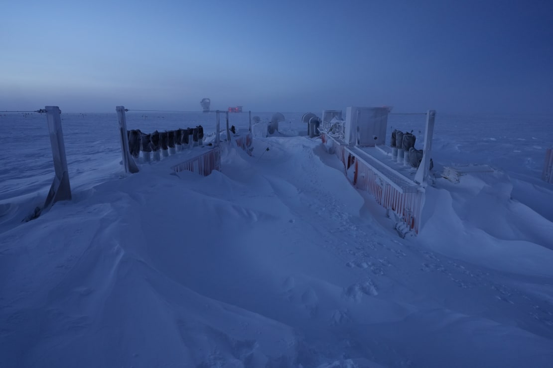Storage containers partially buried in snow drifts.