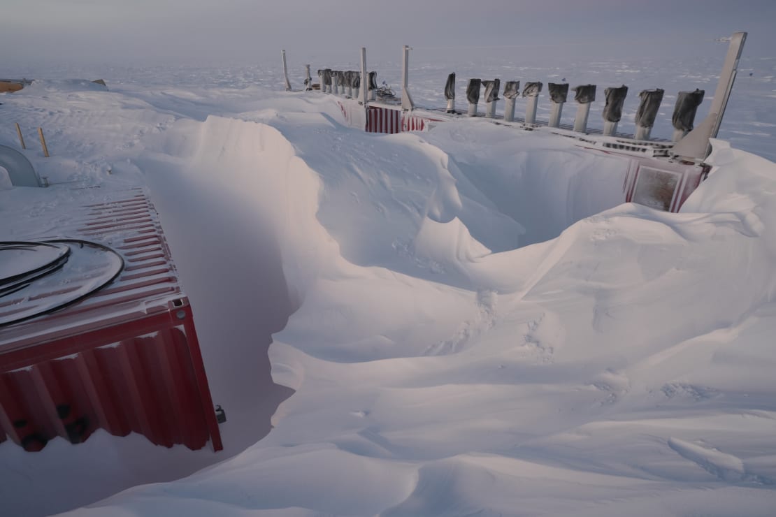Close-up of large snow drift showing lots of angled surfaces between drill camp containers at South Pole.