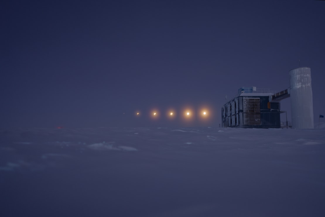 Combined time-lapse image of part of lunar eclipse seen in twilight sky next to IceCube Lab.