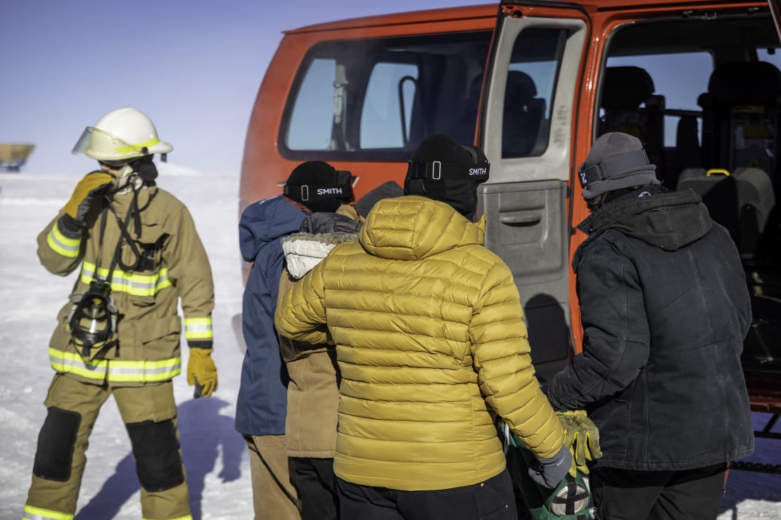 Group of people gathered at side door of emergency response vehicle.