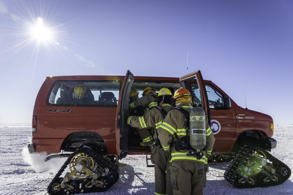 Side view of emergency response vehicle modified for travel on snow and ice.