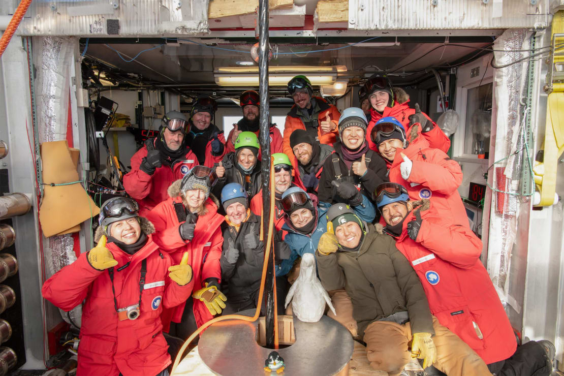 Group photo with smiles and thumbs up around the Upgrade deployment hole.