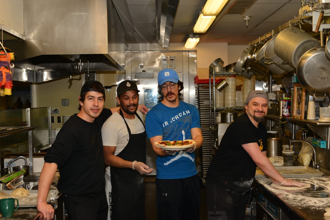 Four pizzaiolos in the South Pole station kitchen.