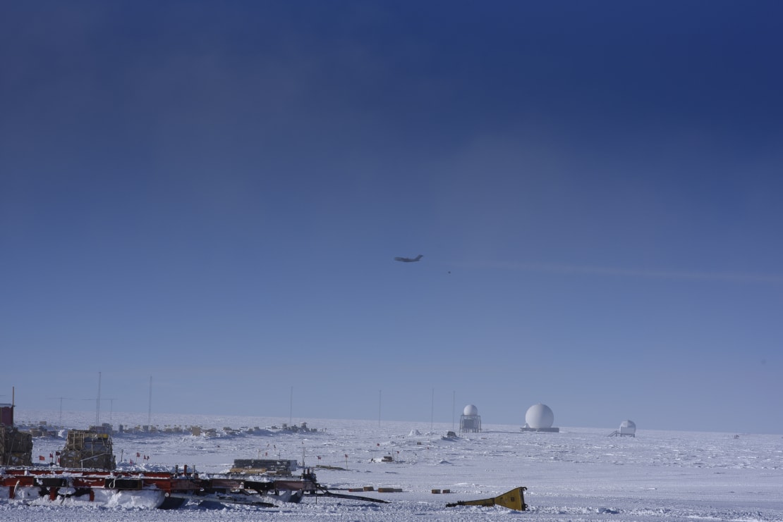 Side view of plane in the air, small in the distance.